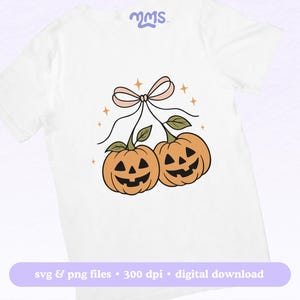 May include: White t-shirt featuring a cartoon illustration of two orange pumpkins with carved faces, connected by green stems and a pink bow. The design includes small star accents. Text at the bottom reads "svg & png files &bull; 300 dpi &bull; digital download."