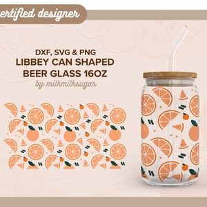 May include: A clear glass beer glass shaped like a can with a wooden lid and a straw. The glass has a pattern of orange slices and small orange circles on it. The text "LIBBEY CAN SHAPED BEER GLASS 16OZ" is printed on the image. The text "by milkmilksugar" is printed below the glass.