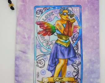 May include: A purple and blue drawstring bag with a colorful illustration of a fairy with wings and a steampunk-inspired outfit. The fairy is blowing a kiss and the bag has the word "LOVE" printed on it.