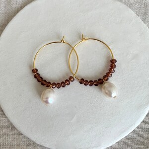 Gold-plated earrings, freshwater pearls and burgundy crystals