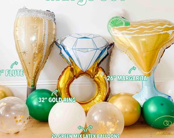 May include: A festive balloon set labeled "Margs Set" includes a 40" flute, a 26" margarita, and a 32" gold ring balloon. Additional balloons are gold, green, white, and confetti-filled. The set is ideal for a celebration.
