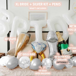 Extra large white letters spelling BRIDE hang above the bed in an arch. Below the letters on the bed rests four large complementing foil balloons, a large flute, a gold ring, a green champagne bottle and 10 silver chrome and confetti filled balloons