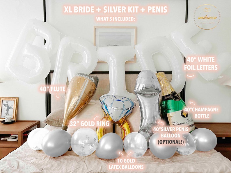Extra large white letters spelling BRIDE hang above the bed in an arch. Below the letters on the bed rests four large complementing foil balloons, a large flute, a gold ring, a green champagne bottle and 10 silver chrome and confetti filled balloons