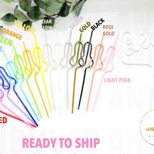 An assortment of rainbow colored swirly straws are arranged on a white background, with one white "Bride" straw.