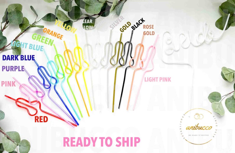 An assortment of rainbow colored swirly straws are arranged on a white background, with one white "Bride" straw.
