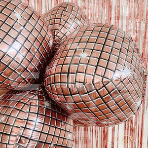 May include: A cluster of four round, rose gold foil balloons featuring a printed grid pattern that mimics the reflective surface of a disco ball. Each balloon has white starburst accents on the grid, creating a shiny, metallic appearance.