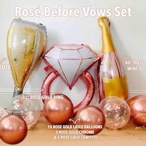 May include: A "Rosé Before Vows Set" includes a 40-inch flute, a 32-inch rose gold ring, a 40-inch rose gold wine bottle, rose gold latex balloons, chrome balloons, and confetti balloons. The set is designed for a wedding or bridal shower.