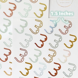 May include: A sheet of stickers with a repeating pattern of 1.5 inch gold, silver, and copper colored breast outlines. The stickers are on a white background.
