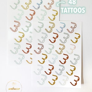 May include: Two sheets of temporary tattoos with 48 individual tattoos of a stylized breast shape in various colors, including gold, copper, and blue. The text "48 TATTOOS" is printed on the top of the image.