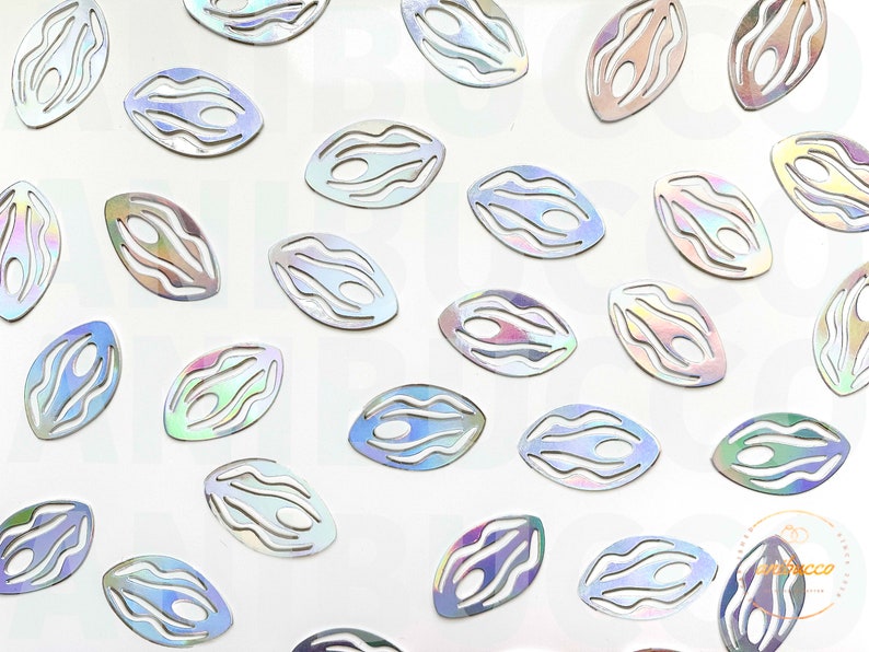 May include: A collection of iridescent silver, oval-shaped, decorative cutouts with a wavy pattern.