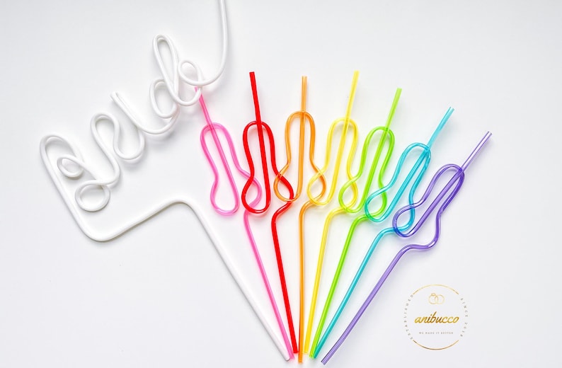 May include: A set of rainbow colored reusable drinking straws with a white plastic straw shaped into the word "bride".