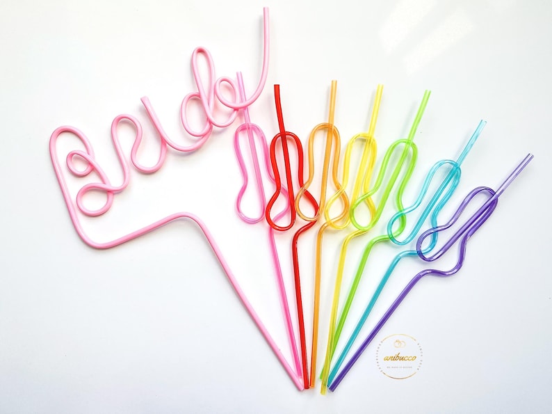 May include: A set of colorful, bendable drinking straws. The straws are arranged in a rainbow pattern, with the pink straw forming the word "bride".