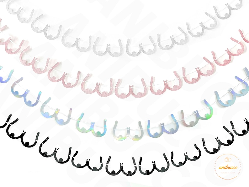 Peut inclure: Une guirlande de cinq rang&eacute;es de d&eacute;coupes en papier paillet&eacute; en forme de seins dans diff&eacute;rentes couleurs, dont l'argent, le rose, l'iridescent et le noir. La guirlande est enfil&eacute;e sur une ficelle blanche.