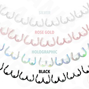 Peut inclure: Une guirlande de d&eacute;coupes en papier en forme de seins dans quatre couleurs&nbsp;: argent, or rose, holographique et noir. La guirlande est enfil&eacute;e sur une ficelle blanche.