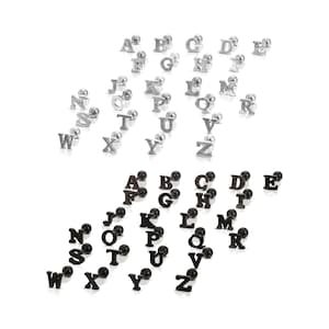 May include: A collection of silver and black letter stud earrings, each featuring a different letter of the alphabet. The silver earrings have a shiny finish, while the black earrings have a matte appearance. The earrings are displayed on a white background.