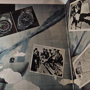 May include: An open book with various images. Two watches with metal bands are displayed at the top. Several black and white photographs are scattered across the page, including images of people and scenes.