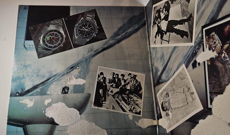 May include: An open book with various images. Two watches with metal bands are displayed at the top. Several black and white photographs are scattered across the page, including images of people and scenes.