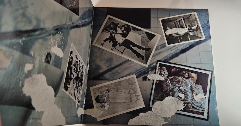 May include: An open book with a blue and white abstract design. Several black and white photographs are scattered across the pages, depicting various scenes. The photos are of different sizes and shapes.