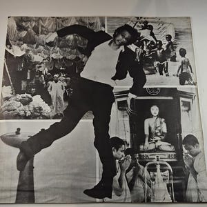 May include: Black and white photograph of a man in motion, superimposed over multiple images. The man is wearing a white shirt, black pants, and a black jacket. The background includes scenes of people and religious imagery.