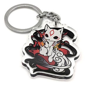以下が含まれることがあります： 赤いマスクをした白いキツネが、黒と赤の炎が燃える雲の上に座っています。キツネは、銀色の金属製のリングが付いたキーホルダーです。