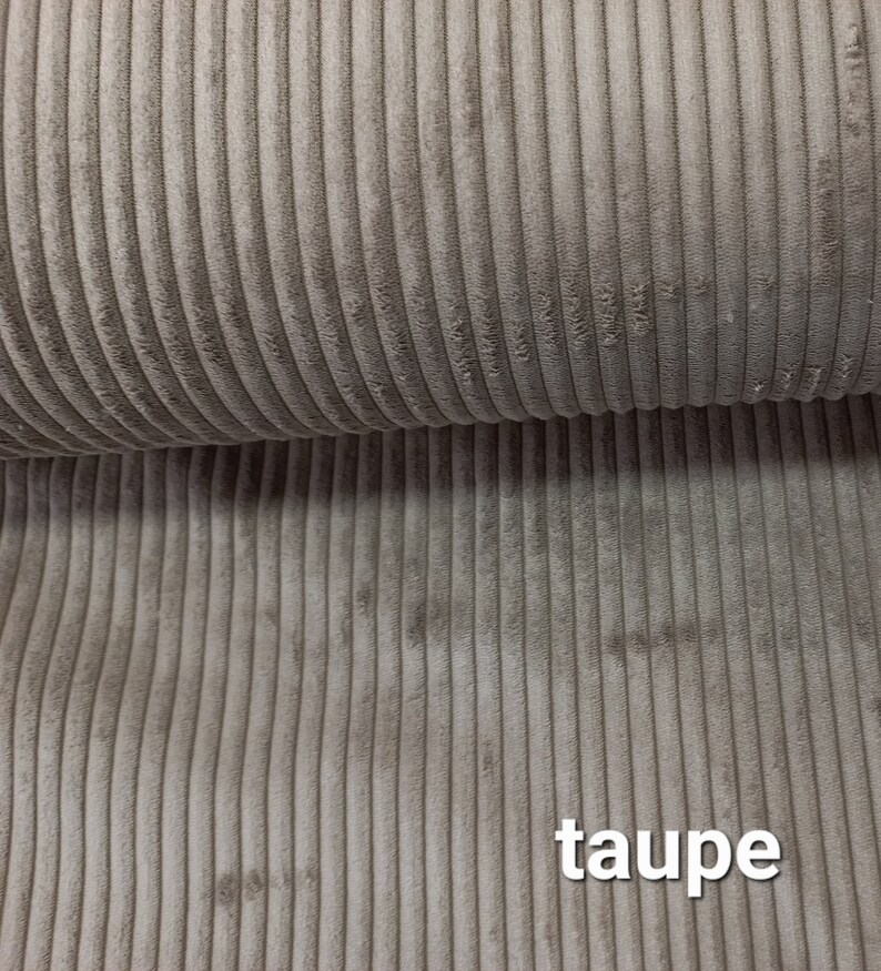 Może przedstawiać: Zbliżenie na tkaninę z  corduroy w kolorze taupe. Tkanina ma żebrowaną fakturę i miękki, pluszowy charakter.