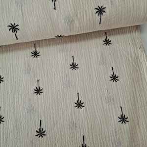 Könnte beinhalten: Weißer Stoff mit schwarzem Palmenbaumdruck. Der Stoff hat eine strukturierte, zerknitterte Optik.