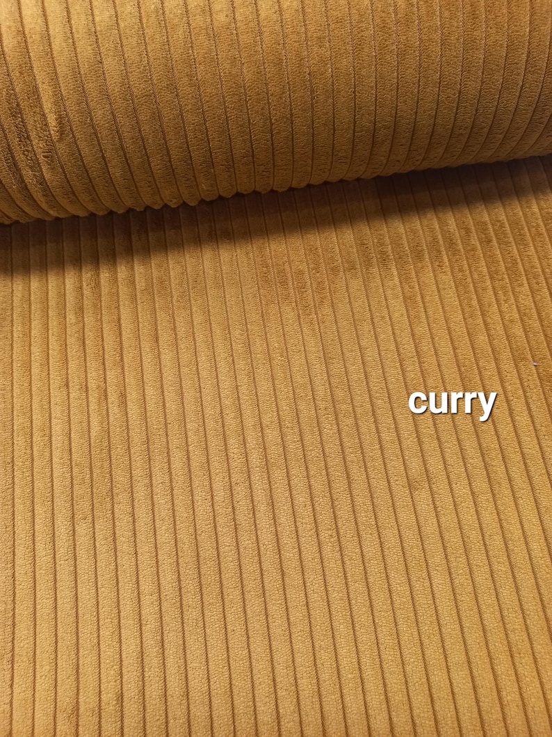 Może przedstawiać: Zbliżenie na tkaninę o fakturze weluru w kolorze curry.