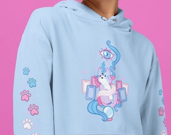 May include: A light blue hoodie with a white cat wearing a pink scarf and a blue eye above it. The cat is surrounded by pink and blue cards and a blue orb. The sleeves of the hoodie have a pattern of pink and blue paw prints.