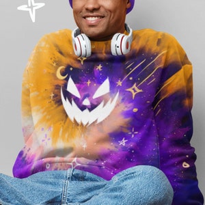May include: A yellow and purple tie-dye sweatshirt with a white jack-o'-lantern face and gold stars. The sweatshirt has a relaxed fit and long sleeves.