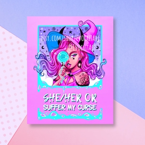 May include: A pink and blue illustration of a witch with a pentagram lollipop. The witch is wearing a black hat with a blue brim and a pink dress. The text "SHE/HER OR SUFFER MY CURSE" is written in white letters on a pink background.