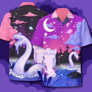 May include: Two purple and pink short-sleeved button-up shirts with a fantasy-themed print. The print features a white castle, a blue lake, a white moon, and a white sea monster. The shirts have a pink collar and a white button closure.