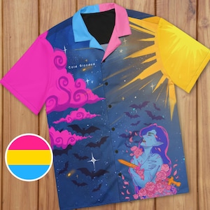 May include: A button-down shirt with a vibrant, artistic design. The shirt features a split design with a night sky and sun motif. The left side has pink clouds, bats, and the text "Cold Blooded." The right side has a sunburst and a figure with roses.