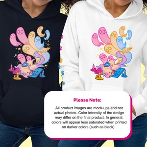 Peut inclure: Un sweat-shirt noir et blanc avec un imprim&eacute; graphique color&eacute; d'un chat entour&eacute; de fant&ocirc;mes. Le graphique comprend &eacute;galement des bougies et des &eacute;toiles. Le texte "Veuillez noter : Toutes les images de produits sont des maquettes et non des photos r&eacute;elles. L'intensit&eacute; des couleurs du motif peut varier sur le produit final. En g&eacute;n&eacute;ral, les couleurs appara&icirc;tront moins satur&eacute;es lorsqu'elles sont imprim&eacute;es sur des couleurs plus fonc&eacute;es (comme le noir)." est imprim&eacute; en bas de l'image.