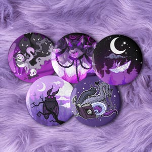 May include: Five purple round buttons with fantasy illustrations. Designs include a cat with ghosts, a wolf with chains, a moth under a crescent moon, a moth on a branch, and an open book with tentacles.