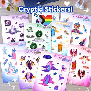 May include: A collection of colorful cryptid stickers featuring various mythical creatures like Mothman, Werewolf, and Dragon. Each sticker sheet has unique illustrations and the text "Cryptid Stickers!" is displayed at the top.