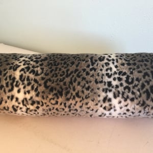 Cuscino con motivo leopardo delle nevi e morbida consistenza in pelliccia; cuscino cilindrico in pelliccia con stampa animalier; cuscino cervicale con stampa leopardata in pelliccia