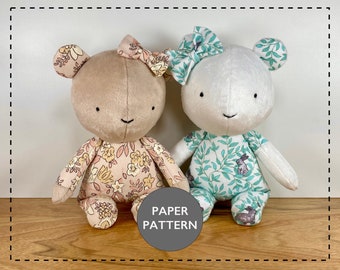 May include: Two plush teddy bears, one with a floral print and the other with a leafy print, sitting on a wooden surface. The text "PAPER PATTERN" is visible in the image.