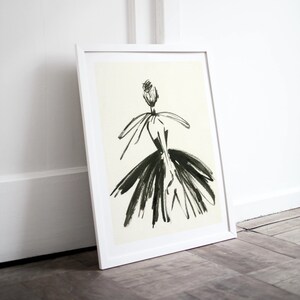 May include: A black and white line drawing of a person wearing a dress with a large skirt. The drawing is framed in a white frame.