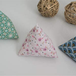 May include: Three triangular fabric cushions with different patterns. The cushions are made of a soft, patterned fabric and are filled with a soft material. The cushions are perfect for adding a touch of style and comfort to any room.