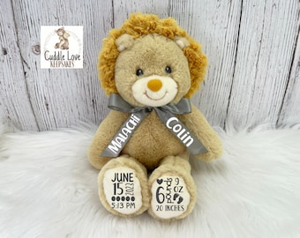 Peut inclure: Un ours en peluche lion avec un ruban gris noué autour de son cou. Le ruban porte les noms "Malachi" et "Colin" imprimés dessus. Les pattes de l'ours ont des détails imprimés sur elles, y compris la date "15 juin 2023", l'heure "17 h 13", le poids "6 livres 9 oz" et la longueur "20 pouces".