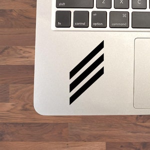 May include: A black and white striped sticker on a silver laptop.