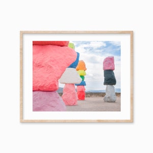 Peut inclure: Une rangée de rochers colorés empilés dans le désert. Les rochers sont peints dans différentes nuances de rose, bleu, vert, jaune et blanc. Les rochers sont disposés en ligne, le rocher le plus haut à l'arrière et le plus bas à l'avant.
