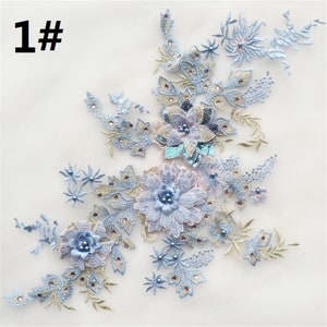 Może przedstawiać: Jasnoniebieska aplikacja kwiatowa z perłowymi akcentami i cekinami. Aplikacja przedstawia skupisko kwiatów z liśćmi i łodygami. Aplikacja idealnie nadaje się do dodania odrobiny elegancji do każdego projektu.