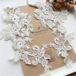 May include: Two white lace appliques with pearl beading and floral designs. The appliques are on a brown background with the text "Natural Style © design by lenqua".