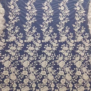 May include: White floral embroidered lace fabric with a delicate pattern. The lace is on a sheer mesh background.