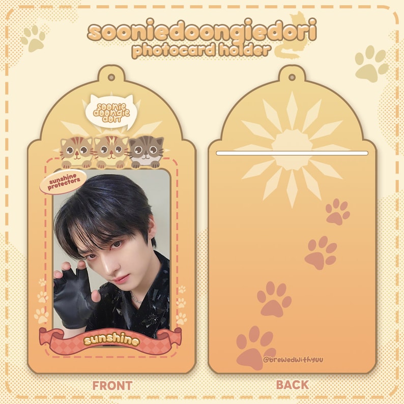 May include: A photocard holder with a front and back. The front features a cartoon image of three cats with the text "sunshine protectors" and a photo of a person. The back features a sun with rays and paw prints. The text "soonie doongie dori photocard holder" is at the top of the holder. The text "sunshine" is at the bottom of the front of the holder. The text "@brewedwithyuu" is at the bottom of the back of the holder.