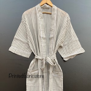 May include: A gray and white striped robe with a self-tie belt and two pockets. The robe has short sleeves and a V-neck.