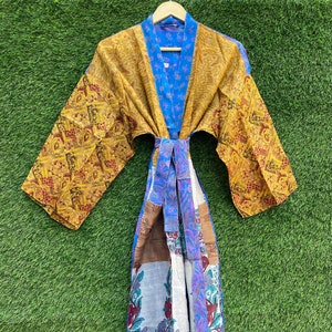 May include: A long, blue, yellow, and white silk robe with a floral pattern. The robe has a sash tie and long sleeves.
