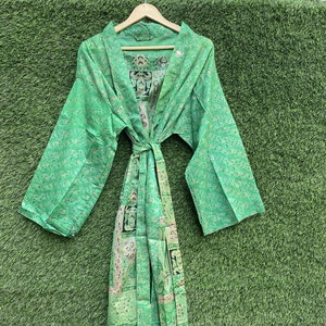 May include: A green silk robe with a floral pattern and a tie belt. The robe has long sleeves and a relaxed fit.