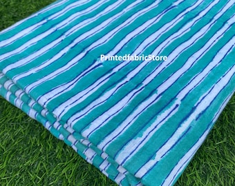 May include: A folded piece of fabric with white and teal blue stripes. The fabric has a hand-painted look and is perfect for crafting projects.